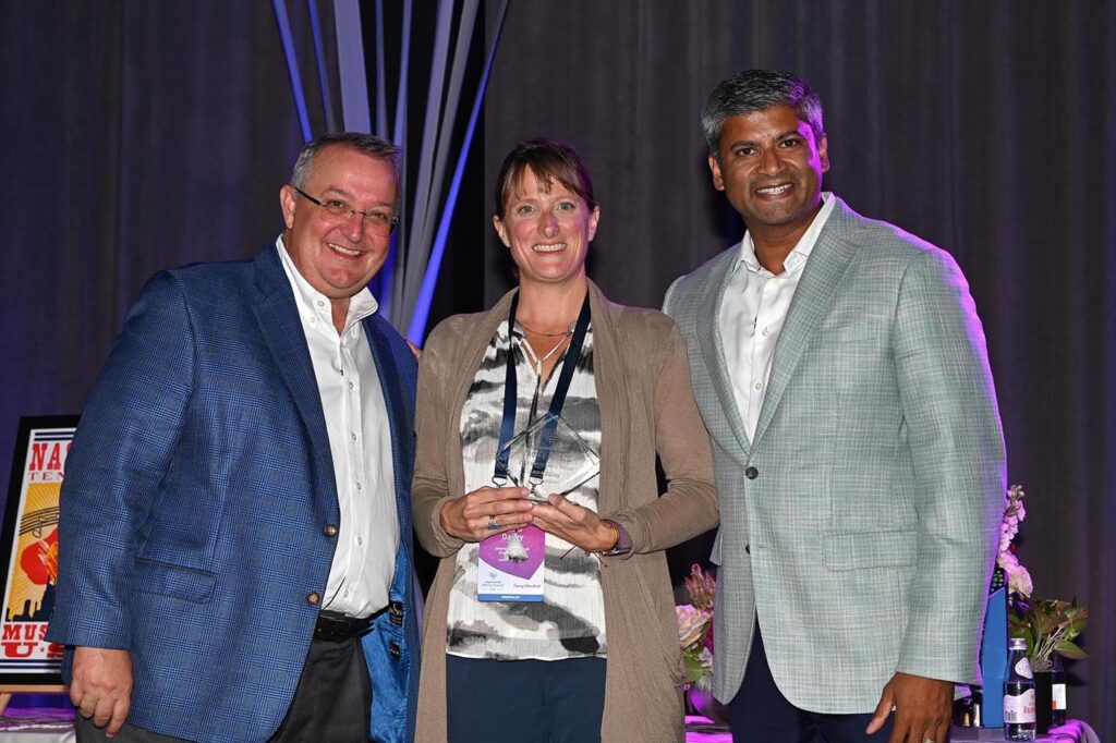 Laura Dailey (center) receives the Mercy Award from Lifepoint Health CEO David Dill (left) and Jason Zachariah (right), president and chief operating officer of Lifepoint Health.
